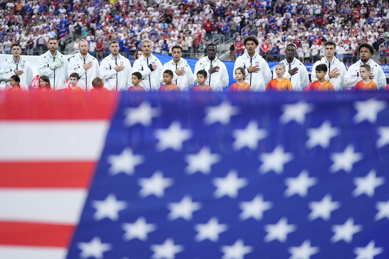Players of United States stand during the national anthem prior to a Copa America Group C soccer match against Bolivia in Arlington, Texas, Sunday, June 23, 2024. (AP Photo/Julio Cortez)