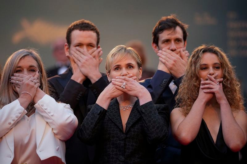 "Me Too" director Judith Godreche, center, poses with hands covering their mouth upon arrival at the premiere of the film 'Furiosa: A Mad Max Saga' at the 77th international film festival, Cannes, southern France, Wednesday, May 15, 2024. (Photo by Andreea Alexandru/Invision/AP)