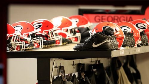 Georgia Bulldogs helmets and shoes sit on the shelf in the Sanford Stadium locker room Saturday, Sept. 2, 2017, in Athens.