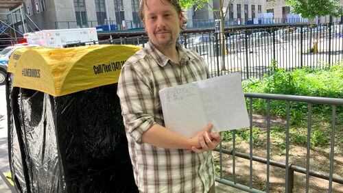 Richard Partington poses for a photo while holding up a line list outside Manhattan Criminal Court, Friday, May 24, 2024, in New York. The word has gotten out that members of the public can attend former President Donald Trump's trial in New York City and the line to get inside the courtroom has gotten longer. A handful of people, including 43-year-old Partington of East Hampton, N.Y., were already lined up Friday for the chance to witness closing arguments on Tuesday. (AP Photo/Karen Matthews)