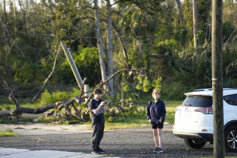 Chase Allbritton flies a drone near downed trees in the aftermath of Hurricane Helene, in Perry, Fla., Friday, Sept. 27, 2024. (AP Photo/Gerald Herbert)