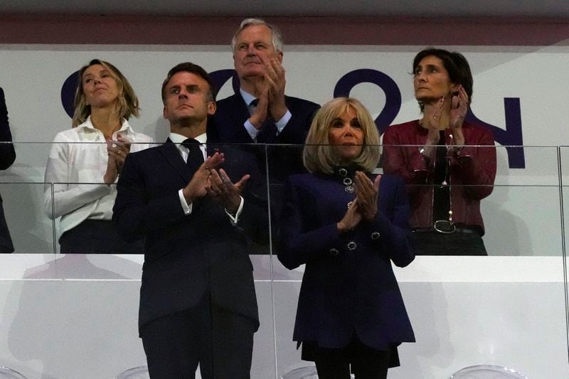 French Prime Minister Michel Barnier, centre back, French President Emmanuel Macron, foreground left, and Macron's wife, Brigitte Macron, foreground right, applaud at the closing ceremony of the 2024 Paralympics, Sunday, Sept. 8, 2024, in Paris, France. (AP Photo/Michel Euler)