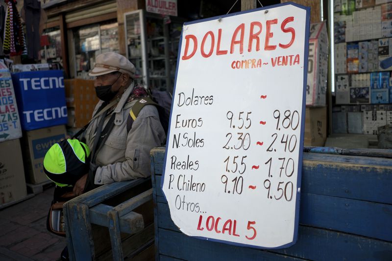 A sign displays currency exchange rates in La Paz, Bolivia, Friday, June 28, 2024, days after Army troops stormed the government palace in what President Luis Arce called a coup attempt. (AP Photo/Carlos Sanchez)