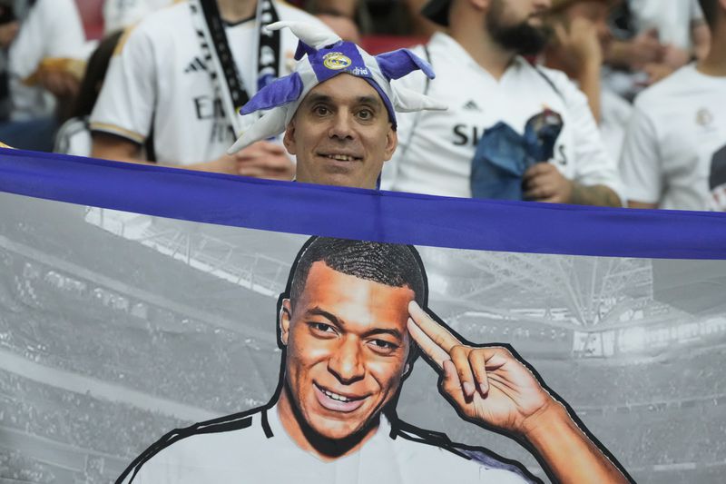 Real Madrid's fan holds a portrait of Kylian Mbappe before the UEFA Super Cup Final soccer match between Real Madrid and Atalanta at the Narodowy stadium in Warsaw, Poland, Wednesday, Aug. 14, 2024. (AP Photo/Czarek Sokolowski)