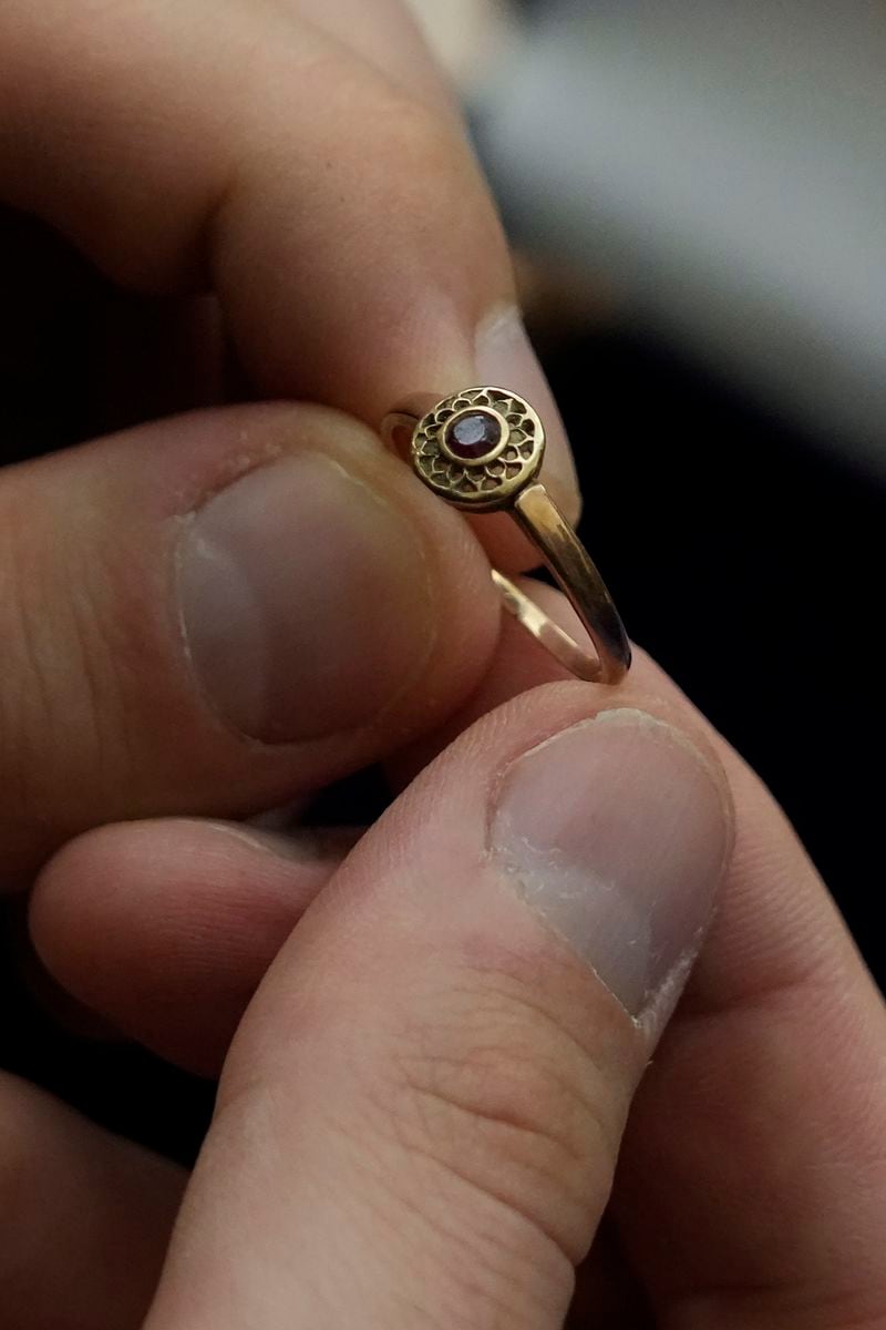 A relative shows a golden ring that was confiscated by Nazi Germans from Zofia Strusińska , who was captured by Nazi troops during Warsaw Uprising in 1944 and taken to a forced labor camp. Her seized items that had been stored at Germany's Arolsen Archives, were returned to Strusińska's relatives in a ceremony in Warsaw, Poland, on Tuesday, Sept. 10, 2024, in which 10 other families also had belongings of their relatives returned.(AP Photo/Czarek Sokolowski)