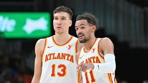 Atlanta Hawks guard Trae Young (11) confers with Atlanta Hawks guard Bogdan Bogdanovic (13) during the fourth quarter in an NBA basketball game at State Farm Arena, Saturday, February 3, 2024, in Atlanta. Atlanta Hawks won 141-134 in overtime. (Hyosub Shin / Hyosub.Shin@ajc.com)