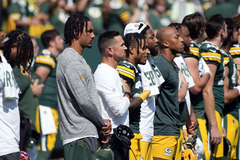 Injured Green Bay Packers quarterback Jordan Love, left, stans with his temamtes for the Natioanl Anthem before the start of an NFL football game against the Indianapolis Colts Sunday, Sept. 15, 2024, in Green Bay, Wis. (AP Photo/Morry Gash)