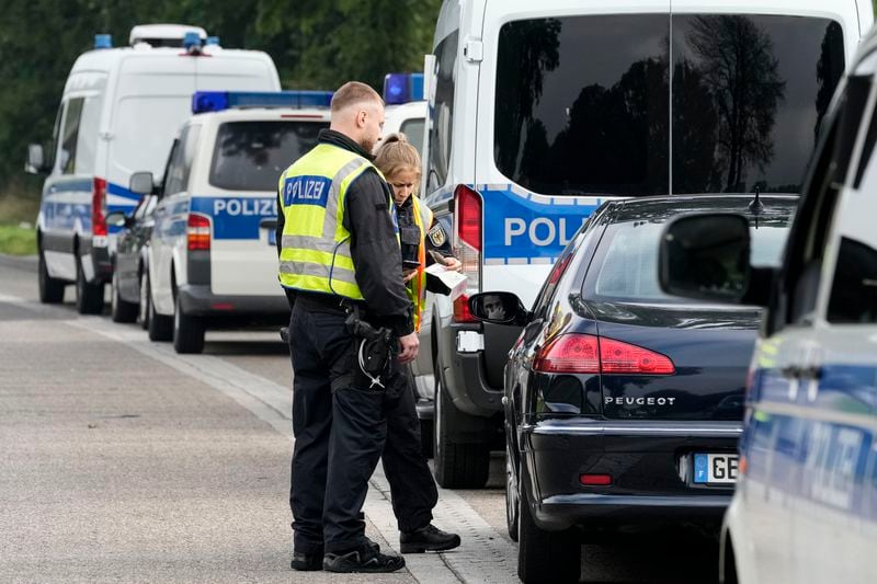 German police check the details of a French car near the border to Belgium in Aachen, Germany, Monday, Sept. 16, 2024, as Germany begins carrying out checks at all its land borders. (AP Photo/Martin Meissner)