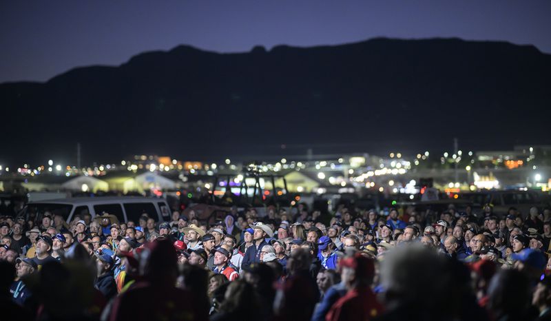 Pilots gather for a briefing just before sunrise prior to the start of the 52nd Albuquerque International Balloon Fiesta in Albuquerque, N.M., on Saturday, Oct. 5, 2024. (AP Photo/Roberto E. Rosales)