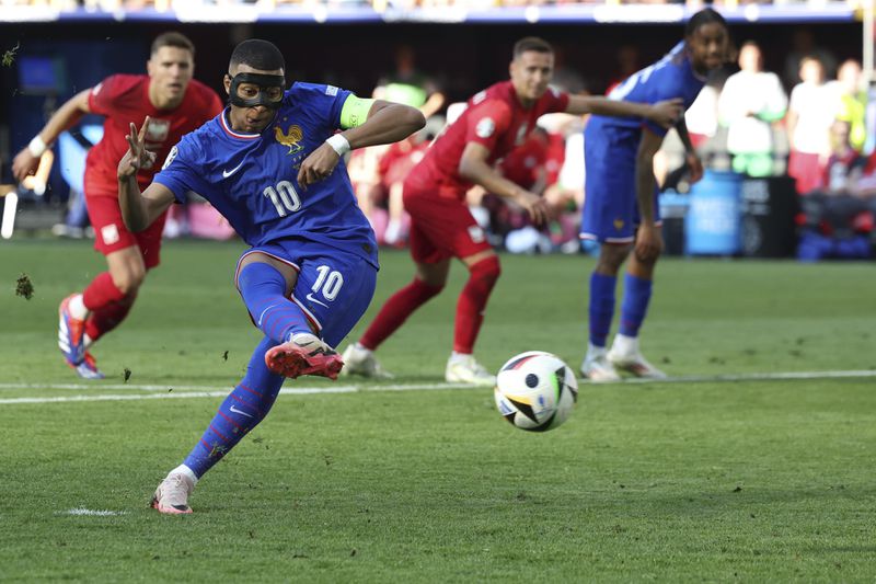 Kylian Mbappe of France sores the opening goal by penalty kick during a Group D match between the France and Poland at the Euro 2024 soccer tournament in Dortmund, Germany, Tuesday, June 25, 2024. (Friso Gentsch/dpa via AP)