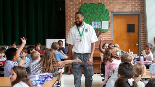 DeKalb County School District elementary security associate Vincent Rhynes loops around Ashford Park Elementary on Monday, Sept. 16, 2024, where he makes his way through lunch to secure locked doors, checks in on classrooms and walks the perimeter of the property. He's one of dozens of new hires who will help secure elementary campuses in the state's third-largest school system. (Jenni Girtman for the AJC)