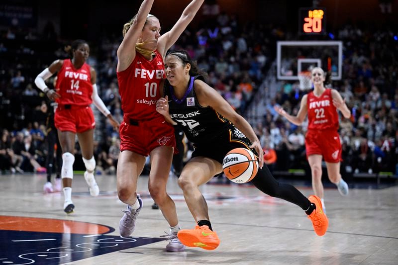 Connecticut Sun guard Veronica Burton (22) drives to the basket as Indiana Fever guard Lexie Hull (10) defends during the second half in Game 2 of a first-round WNBA basketball playoff series, Wednesday, Sept. 25, 2024, in Uncasville, Conn. (AP Photo/Jessica Hill)