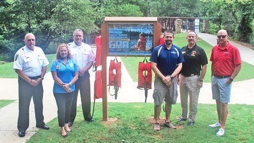 Attending the dedication of a life jacket loaner station at Olde Rope Mill Park are (from left) Cherokee County Fire Chief Tim Prather; Lisa Grisham, senior fire and life educator; Cherokee Assistant Fire Chief Eddie Robinson; Michael D. Huffstetler, Woodstock Parks and Recreation director; Sgt. George Williams, Woodstock Fire & Rescue; and Chris Day, Tow Boat US and BoatUS Foundation.