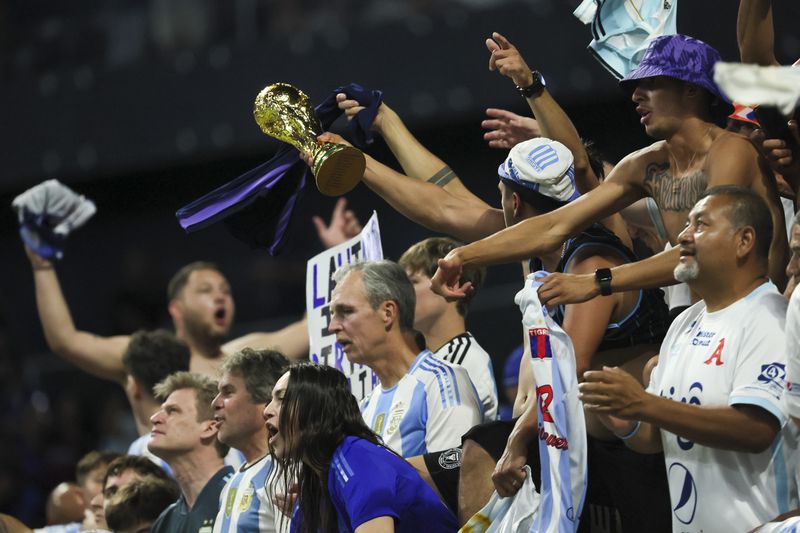 Argentina fans celebrate their 2-0 win with a replica of the World Cup Trophy after Argentina’s match against Canada in the 2024 Copa America at Mercedes-Benz Stadium, Thursday, June 20, 2024, in Atlanta. (Jason Getz/AJC)
