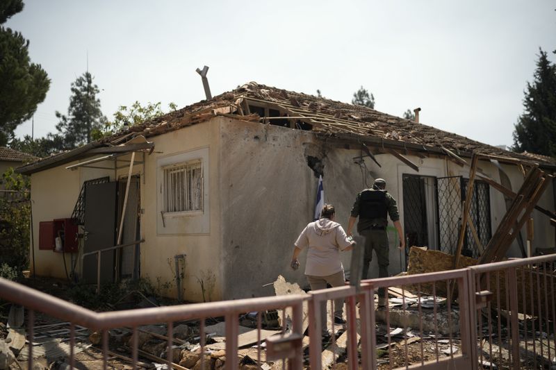 People look at a damaged house that was hit by a rocket fired from Lebanon, near Safed, northern Israel, on Wednesday, Sept. 25, 2024. (AP Photo//Leo Correa)