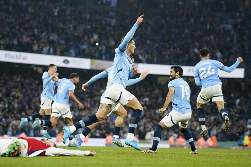 Manchester City's John Stones, center, celebrates scoring his side's second goal during the English Premier League soccer match between Manchester City and Arsenal at the Etihad stadium in Manchester, England, Sunday, Sept. 22, 2024. (AP Photo/Dave Thompson)