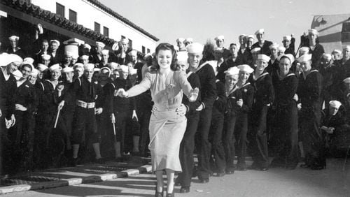 Rita Hayworth leads a line of sailors in the bunny hop at a USO show; Courtesy of Turner Classic Movies