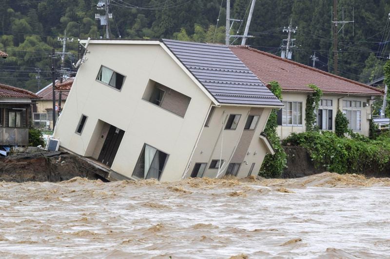 A house leans as a swollen river undermines the ground in Suzu, Japan, Sunday, Sept. 22, 2024, following heavy rain in central Japan's Noto peninsula area, where a devastating earthquake took place on Jan. 1. (Kasumi Fukudome/Kyodo News via AP)