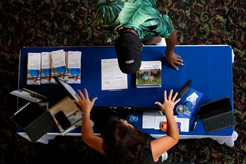 A woman talks to an attendee at the Black Health Matters Health Summit and Expo in New York, Thursday, Aug. 15, 2024. (AP Photo/Pamela Smith)