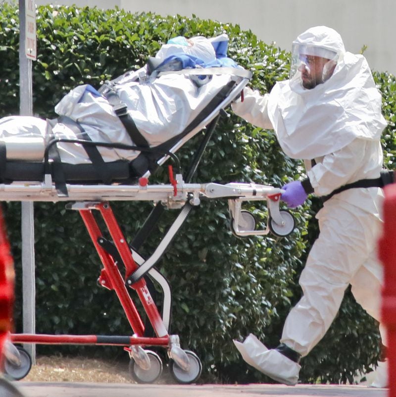 In this file photo, medical workers roll patient Nancy Writebol into Emory University Hospital. The second American aid worker infected with Ebola arrived Aug. 5, 2014, in Atlanta. Writebol arrived in a chartered jet at Dobbins Air Reserve Base and was then taken in an ambulance to Emory University Hospital. She was rolled into the hospital by suited medical personnel. Three days earlier, Dr. Kent Brantly, also diagnosed with the virus, arrived at Emory University Hospital and walked from the ambulance. Both recovered. JOHN SPINK / JSPINK@AJC.COM