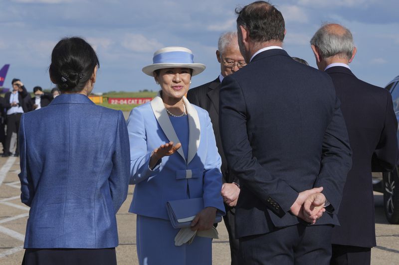 Empress Masako gestures as she speaks to dignitaries as she and Emperor Naruhito arrive at Stansted Airport, England, Saturday, June 22, 2024, ahead of a state visit. The state visit begins Tuesday, when King Charles III and Queen Camilla will formally welcome the Emperor and Empress before taking a ceremonial carriage ride to Buckingham Palace. (AP Photo/Kin Cheung)