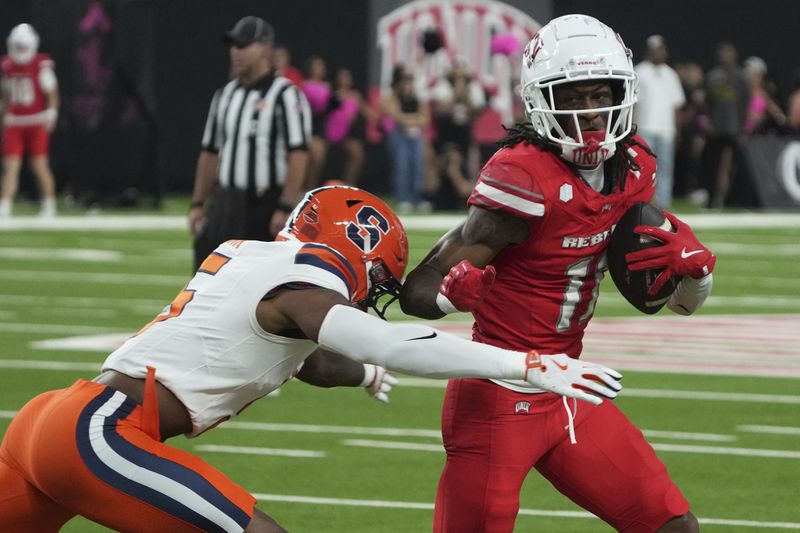 UNLV wide receiver Ricky White III (11) runs around Syracuse defensive back Alijah Clark in the second half during an NCAA college football game, Friday, Oct. 4, 2024, in Las Vegas. (AP Photo/Rick Scuteri)