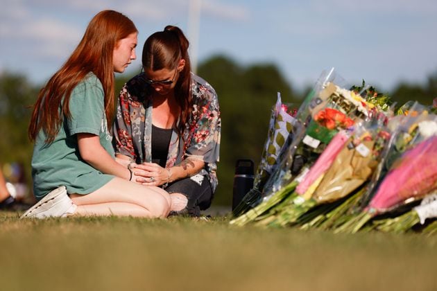 Apalachee High School sophomore Payton Owen, 15, and her mother, Stacey Andrews, offer a prayer by the memorial outside the school on Thursday, Sept. 5, 2024. A 14-year-old is accused of shooting and killing two fellow students and two teachers and injuring nine others at Apalachee High School on Wednesday. (Miguel Martinez/AJC)