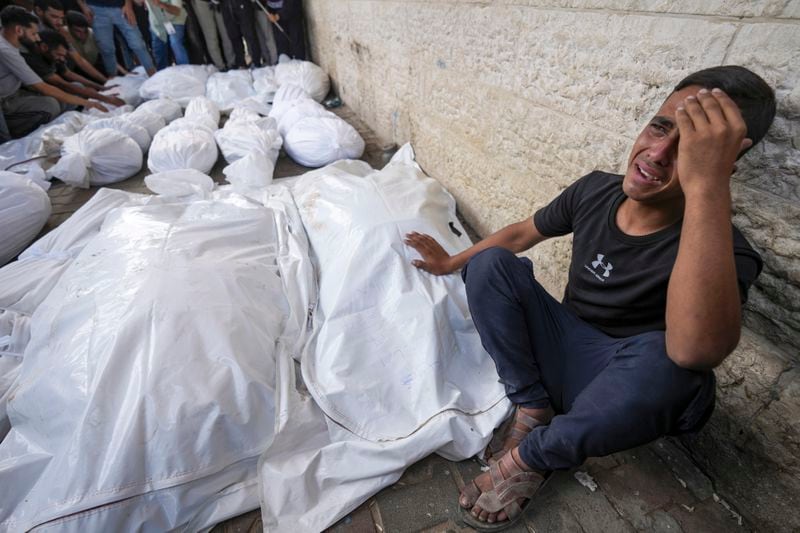 A Palestinian weeps at the funeral for more than 15 people, including four children and several women, killed in an Israeli strike, at Al-Aqsa Martyrs Hospital in Deir al-Balah, Gaza Strip, Saturday, Aug. 17, 2024. The strike hit a house and an adjacent warehouse sheltering displaced people at the entrance of the town of Zawaida, according to the hospital where the casualties were taken. (AP Photo/Abdel Kareem Hana)