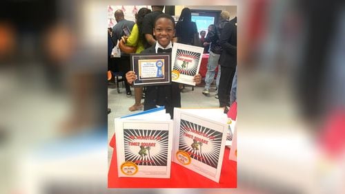 Jaycion Clowers proudly displays his book, "The Monster on Times Square," as well as a certificate presented to each young author. (Photo provided by Alice Queen)