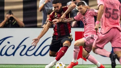 Inter Miami forward Lionel Messi (10), right, and Atlanta United defender Derrick Williams (3) battle for control of the ball during the second half of a MLS soccer match Wednesday, Sept. 18, 2024. (AP Photo/John Bazemore)