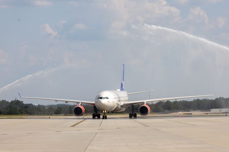 A Scandinavian Airlines plane from Copenhagen arrives to a water cannon welcome at Hartsfield-Jackson airport in Atlanta on Monday, June 17, 2024. The airport and airline hosted an inaugural flight event for a new route of daily nonstop flights between Atlanta and Copenhagen. (Arvin Temkar / AJC)