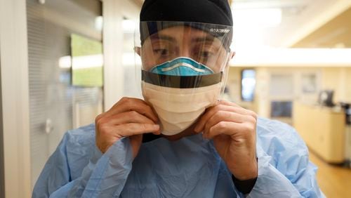 Northeast Georgia Medical Center registered nurse Dylan Glass is fully masked up as he prepares to provide medical care to patients infected with COVID-19 back in February.
Photo by Miguel Martinez /miguel.martinezjimenez@ajc.com