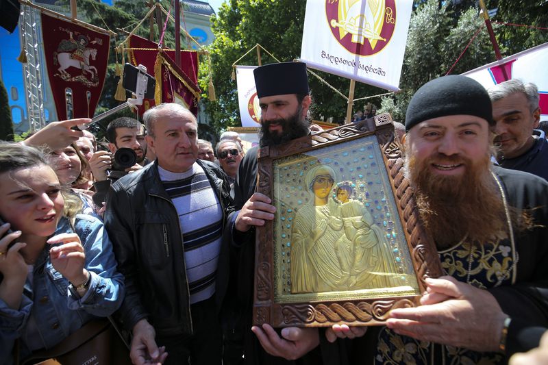 FILE – Georgian Orthodox Church clergymen and supporters gather to celebrate the Day of Family Purity in the conservative country where sentiment is strong against the LGBTQ+ community, in front of parliament in Tbilisi, Georgia, on May 17, 2024. (AP Photo/Zurab Tsertsvadze, File)