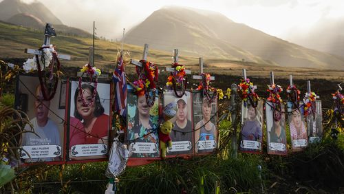 FILE - Photos of victims are displayed under white crosses at a memorial for the August 2023 wildfire victims, above the Lahaina Bypass highway, Dec. 6, 2023, in Lahaina, Hawaii. The death toll from the deadliest U.S. wildfire in over a century, which devastated the historic town of Lahaina on the Hawaiian island of Maui last year, has risen to 102, authorities said Monday, June 24, 2024. (AP Photo/Lindsey Wasson, File)