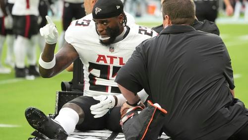 Atlanta Falcons safety DeMarcco Hellams (23) is assisted off the field during the first half of a pre season NFL football game against the Miami Dolphins, Friday, Aug. 9, 2024, in Miami Gardens, Fla. (AP Photo/Wilfredo Lee)