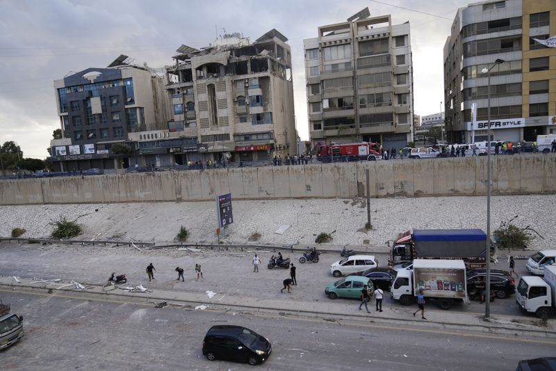 Rescuers arrive at the site of a building that was hit in an Israeli airstrike in Bir Hassan, Beirut, Lebanon, Tuesday, Oct. 1, 2024. (AP Photo/Hussein Malla)