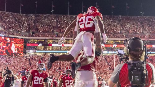 Alabama running back Jam Miller (26) celebrates his touchdown with offensive lineman Kadyn Proctor during the first half of an NCAA college football game against Georgia, Saturday, Sept. 28, 2024, in Tuscaloosa, Ala. (AP Photo/Vasha Hunt)