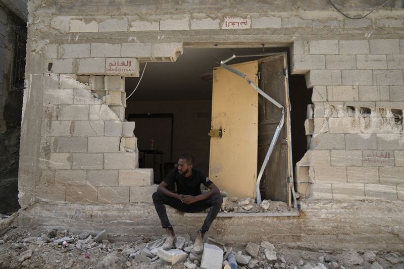 A Palestinian refugee sits by his partly destroyed house that was damaged during the Israeli army operation in the West Bank refugee camp of Tulkarem, in Tulkarem, Thursday, Sept. 5, 2024. (AP Photo/Nasser Nasser)