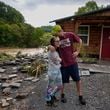 Jonah Wark, right, kisses his wife Sara Martin outside their flood damaged home on the Pigeon River, Saturday, Sept. 28, 2024, in Newport, Tenn. (AP Photo/George Walker IV)