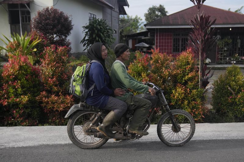 Forest ranger Rosita, left, rides on a motorbike with her husband Muhammad Saleh, a former poacher, as they leave for a forest patrol at their house in Damaran Baru, Aceh province, Indonesia, Tuesday, May 7, 2024. It took years, but eventually Saleh felt the message of his wife. He stopped poaching and cutting down trees and began joining his wife on patrols of the forest. (AP Photo/Dita Alangkara)