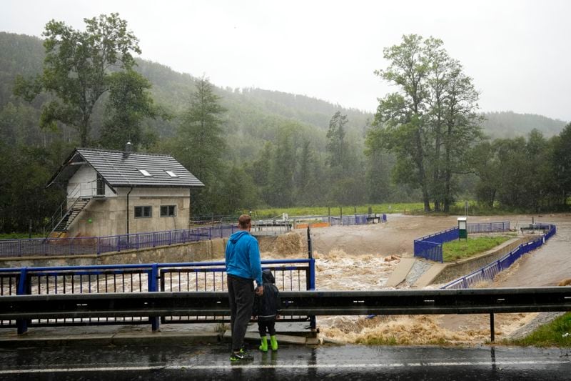 Residents watch the rising levels of the Opava river near Brantice, Czech Republic, Saturday, Sept. 14, 2024. (AP Photo/Petr David Josek)