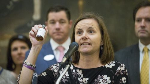 Shannon Cloud, a parent of a child who suffers from Dravet, a rare form of epilepsy, seizures, holds up a bottle of THC oil during a press conference in the rotunda of the Georgia State Capitol building 2019. Cloud was surrounded by other families and lawmakers as they proposed a law that would grant the legalization of growing and distributing medical marijuana to registered patients (ALYSSA POINTER AJC File photo)