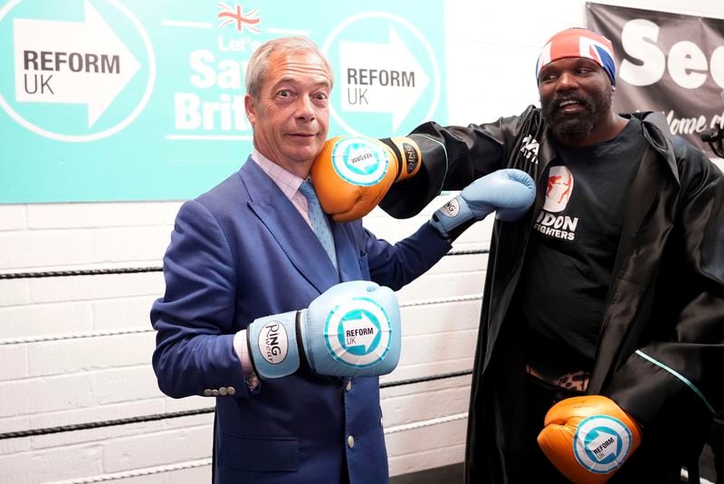 British Reform UK leader Nigel Farage (left) and boxer Derek Chisora at a boxing gym in Clacton, England, while on the General Election campaign trail, Wednesday July 3, 2024. (Ian West/PA via AP)