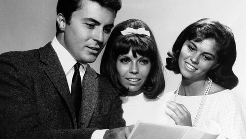 FILE - James Darren — left, one of the stars of the film For Those Who Think Young — chats with Nancy Sinatra, centre, and Claudia Martin about their film debuts, August 13, 1963. (AP Photo, File)