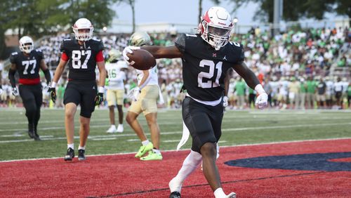 Milton running back TJ Lester (21) reacts after scoring a rushing touchdown during the first half against Buford at Milton High School, Friday, August 16, 2024, in Milton, Ga. This game is between two of the top teams in the state, as Milton is ranked No. 1 in Class 5A and Buford is ranked No. 1 in Class 6A. (Jason Getz / AJC)
