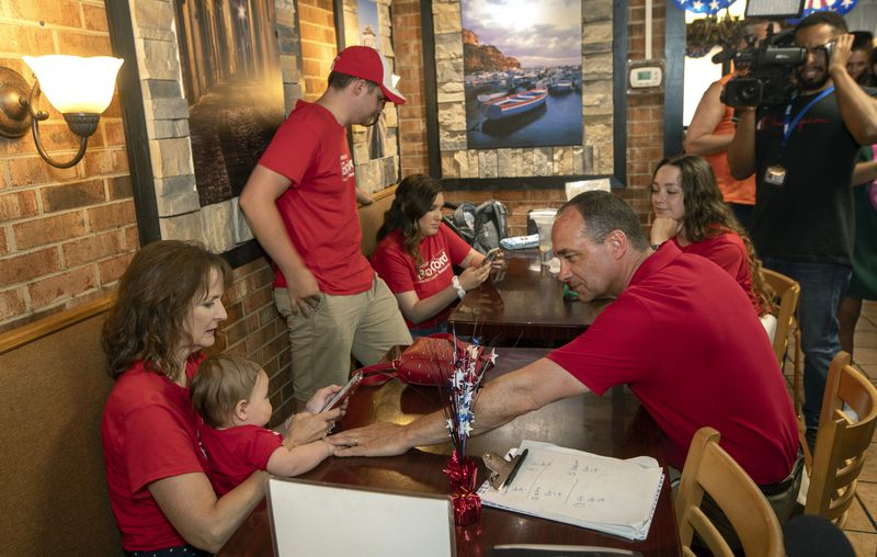 Rep. Bob Good, front right, a candidate in the Republican primary for the state's 5th Congressional District, sits with his wife Tracey and family during a watch party in Lynchburg, Va., Tuesday, June 18, 2024. (AP Photo/P. Kevin Morley)