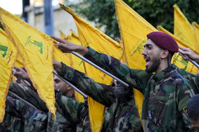 Hezbollah members raise their group flags and chant slogans as they attend the funeral procession of Hezbollah commanders Ibrahim Kobeisi and Hussein Ezzedine in Beirut's southern suburb, Wednesday, Sept. 25, 2024. (AP Photo/Hassan Ammar)