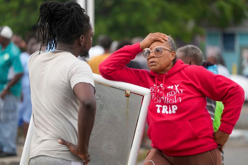Sylvia Small, right, waits for police approval to enter the pier to check her boat's damages due to Hurricane Beryl at the Bridgetown Fisheries in Barbados, Monday, July 1, 2024. (AP Photo/Ricardo Mazalan)