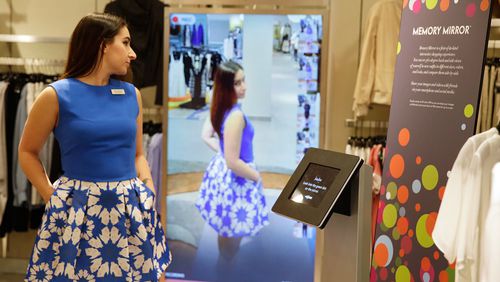 Sales manager Alysa Stefani demonstrates the Memory Mirror at the Neiman Marcus store in San Francisco's Union Square. The mirror is outfitted with sensors, setting off motion-triggered changes of clothing. The mirror also doubles as a video camera, capturing a 360 degree view of what an outfit looks like and making side-by-side comparisons. (AP Photo/Eric Risberg)