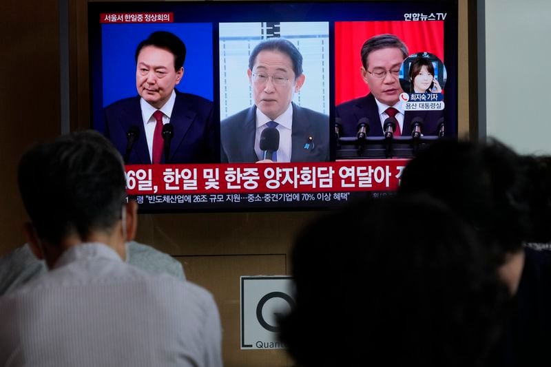 A TV screen shows file images of South Korean President Yoon Suk Yeol, left, Japanese Prime Minister Fumio Kishida and Chinese Premier Li Qiang, right, during a news program at the Seoul Railway Station in Seoul, South Korea, Thursday, May 23, 2024. Leaders of South Korea, China and Japan will meet next week in Seoul for their first trilateral talks in more than four years, South Korea's presidential office announced Thursday. (AP Photo/Ahn Young-joon)
